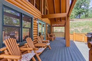 Relax on the covered porch with Adirondack chairs and enjoy the view of the surrounding landscape.
