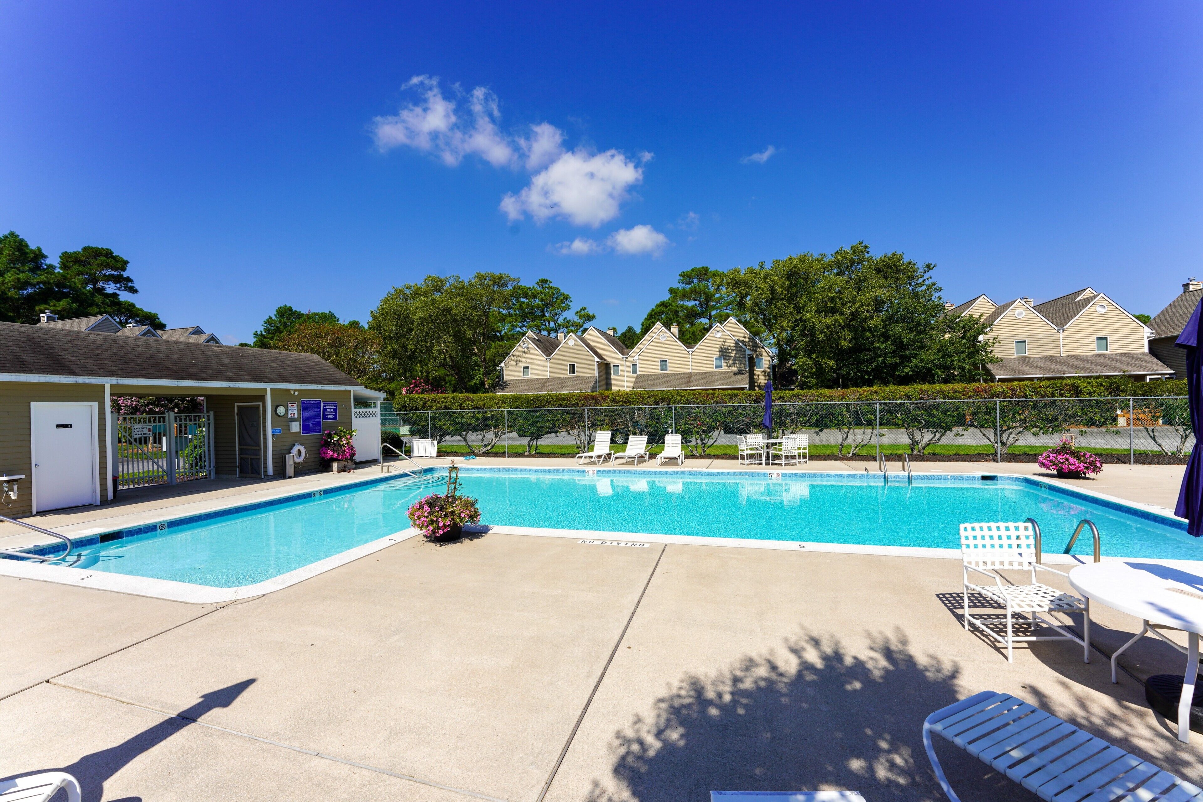 Stewards Watch - Neighborhood Swimming Pool - Residents enjoy a refreshing L-shaped outdoor pool surrounded by a spacious sun deck, perfect for a relaxing afternoon away from the beach.