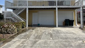 Una casa a due piani con un balcone, un garage e un vialetto.