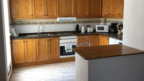A kitchen with wooden cabinets, a microwave, a toaster, and a coffee maker.