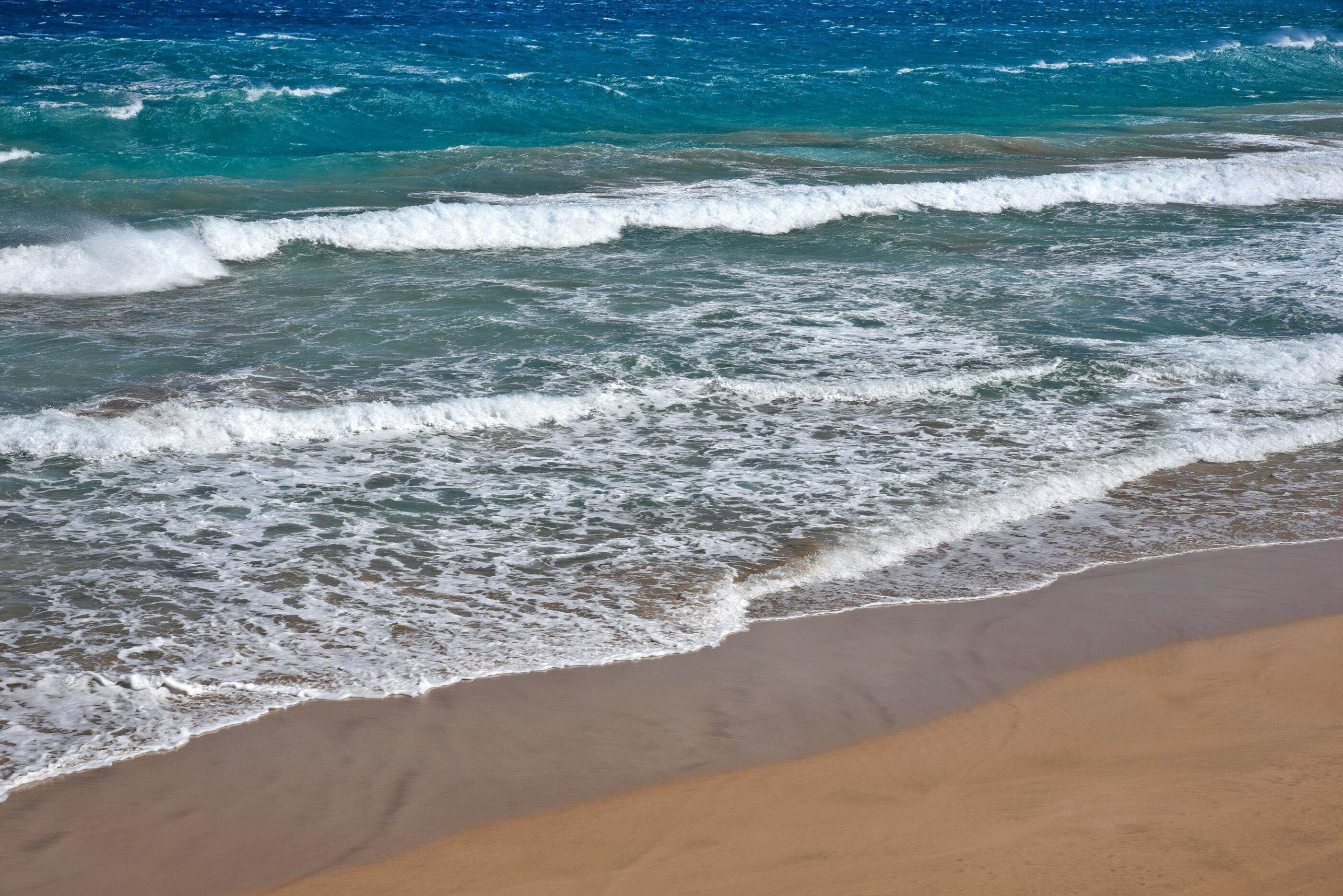 A beach with waves crashing onto the shore.