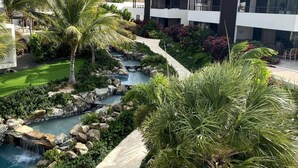 Un hôtel moderne doté d’un jardin aménagé, d’une petite cascade et d’une piscine.