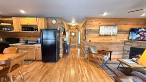 Un interior de madera con cocina, comedor y chimenea.