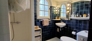 Een douche, een bubbelbad, handdoeken, toiletpapier
