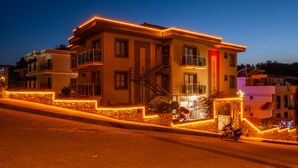A multi-story building with a stone facade, a staircase leading to the upper floors, and a balcony. - Siriusmi hotel (Cesme)