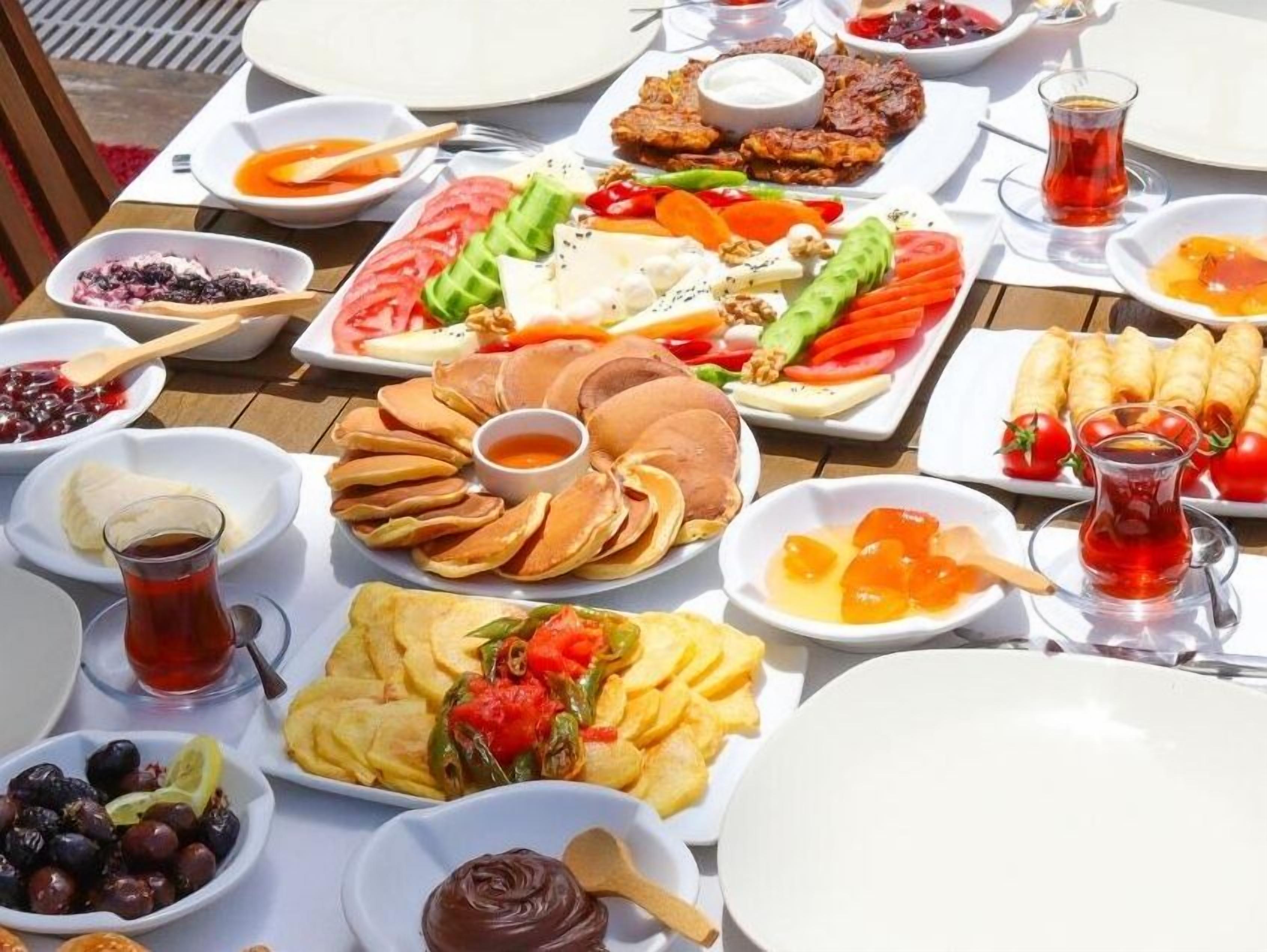 A table set with various dishes including bread, vegetables, and dips, suggesting a communal meal setting.