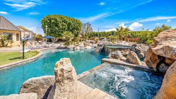 A pool area with a hot tub, lounge chairs, and a basketball court. - The Bentley Estate: Festivals, Karaoke, Grotto, Sauna, Putting Green, BBQ! (Bermuda Dunes)