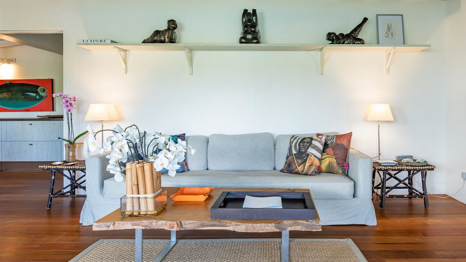 A living room with a sofa, a coffee table, and decorative items including sculptures and a framed picture.