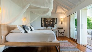 A bedroom with a bed, a desk, a chair, and a large window. - Marigot Bay Luxury villa (St Barths)