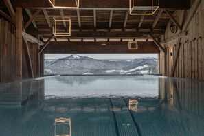 Una piscina interna con vista su montagne innevate.