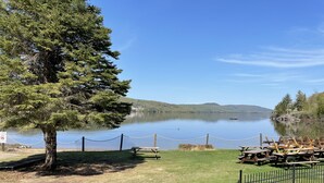 Blick auf einen See mit Picknicktischen und einem eingezäunten Bereich.