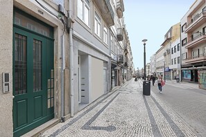 Een straat met keien, omzoomd door historische gebouwen, waarvan sommige balkons en winkelgevels hebben.