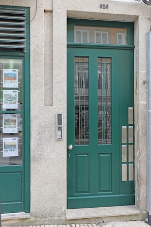Eine grüne Tür mit Briefschlitz und kleinem Fenster darüber.