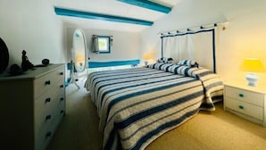 Un dormitorio con cama, mesitas de noche, cómoda, espejo y ventana con cortinas.