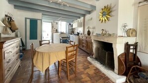 Una cocina acogedora con chimenea, muebles de madera y mantel estampado.