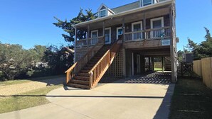 A two-story house with a wooden staircase leading to a balcony. - Hydeaway: Convenient to Restaurants, Shops and Silver Lake (Ocracoke)
