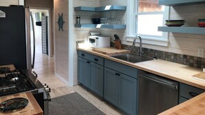 A modern kitchen with wooden cabinets, a stainless steel sink, and a built-in oven.
