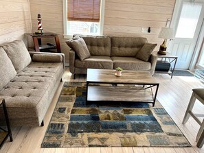 Relax in this inviting living room with a tufted sofa, armchair, and patterned rug.