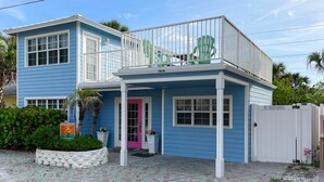 A two-story building with a balcony, a pink door, and a 'NO TRESPASSING' sign.