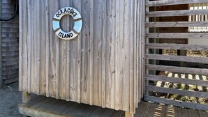 A wooden structure with a circular sign reading "Ocracoke Island." - Sea No Evil: Dog friendly, family friendly, decks, close to the beach. (Ocracoke)