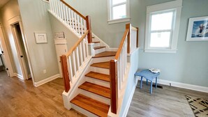 Una escalera con escalones de madera y barandillas blancas que lleva a un piso superior.