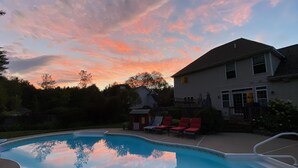 Une piscine offrant une vue dégagée sur le ciel, avec une maison en arrière-plan.
