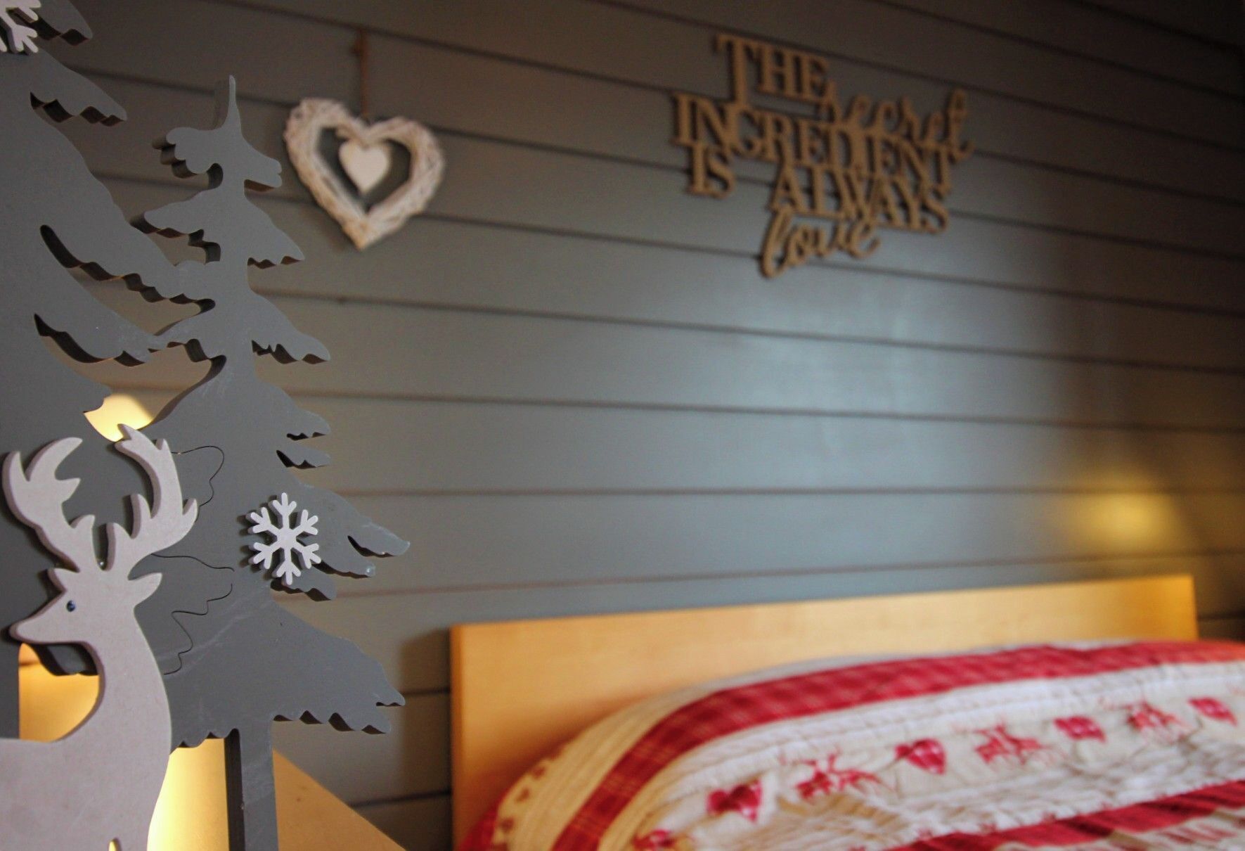 A bedroom with a bed, a wall-mounted decoration, and a wooden headboard.
