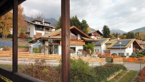 A residential area with modern houses, a wooden fence, and a mountainous backdrop. - Casa 4 Pioppi - View and relaxation (Cavalese)