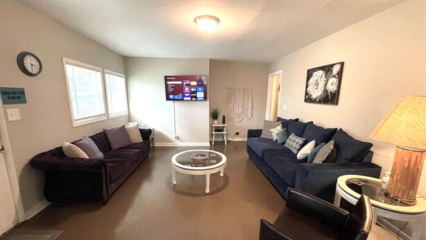 A living room with two couches, a coffee table, a TV, and a lamp.