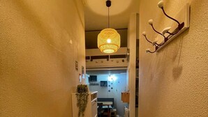 A narrow hallway with a ceiling light, a coat rack, and a refrigerator. - Renovated 4-person studio with lake view Artouste Fabrège (Laruns)