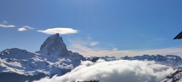 Een met sneeuw bedekte bergtop met een heldere lucht erboven.