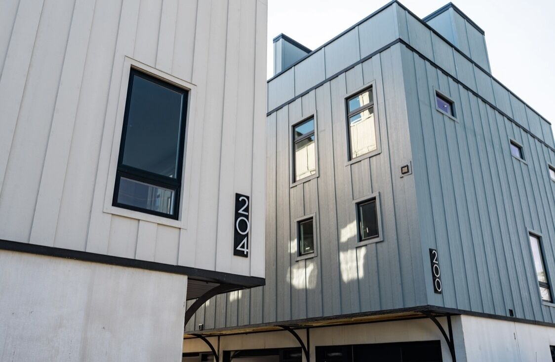 A modern building with a white facade and a grey upper section.