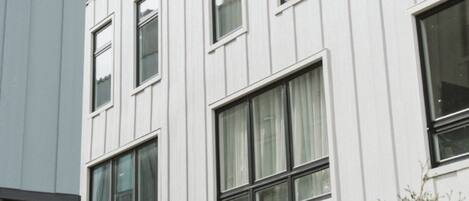 Un immeuble moderne à plusieurs étages, doté de grandes fenêtres et d’une façade plane.