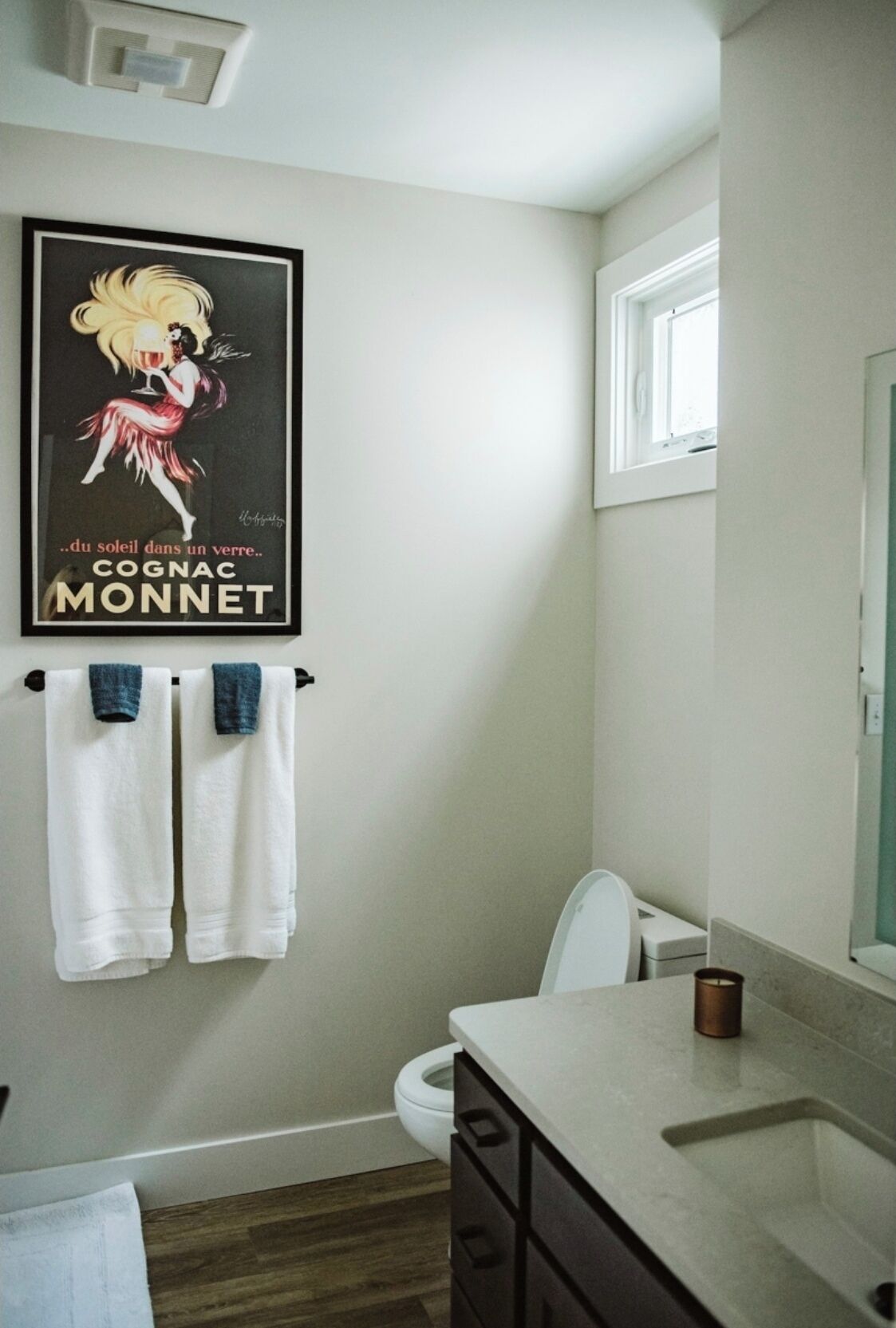 Ein Badezimmer mit Toilette, Waschbecken und einem Bild an der Wand.