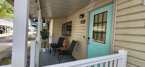 Step out onto the porch and enjoy the tranquil atmosphere, where a comfortable seating area invites relaxation with a pair of chairs and a small table.