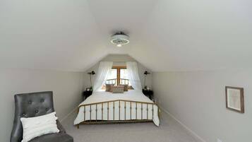Une chambre à coucher avec un lit, une chaise et un ventilateur de plafond.