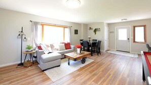 Un salon spacieux avec un canapé, une table basse et un coin repas.
