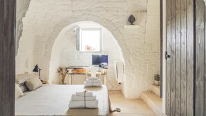 Een gezellige slaapkamer met een bed, een bureau met een computer en een raam.