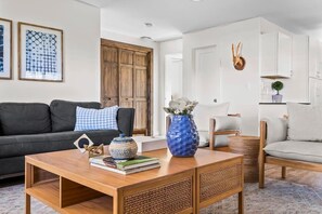 A modern living room with a sofa, coffee table, and decorative items. - 10 Bedroom / Pool / Hot tub / Pickleball / Firepit (Dripping Springs)