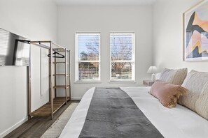 A bedroom with a bed, a wardrobe, a window, and a painting on the wall. - 10 Bedroom / Pool / Hot tub / Pickleball / Firepit (Dripping Springs)