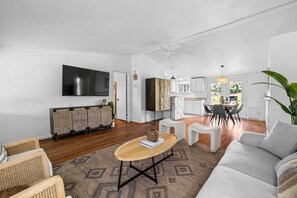 A modern living room with a sofa, a coffee table, and a TV mounted on the wall. - 10 Bedroom / Pool / Hot tub / Pickleball / Firepit (Dripping Springs)