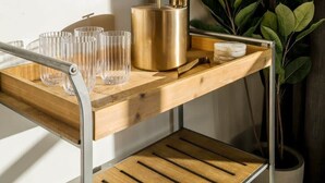 A wooden shelf with glasses and a gold container, a potted plant, and a window with sunlight. - 10 Bedroom / Pool / Hot tub / Pickleball / Firepit (Dripping Springs)