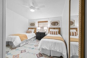 A hotel room with two beds, a ceiling fan, a nightstand with a lamp, and a patterned rug. - 10 Bedroom / Pool / Hot tub / Pickleball / Firepit (Dripping Springs)