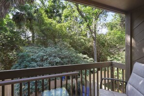 Un balcon donnant sur une forêt verdoyante et luxuriante.
