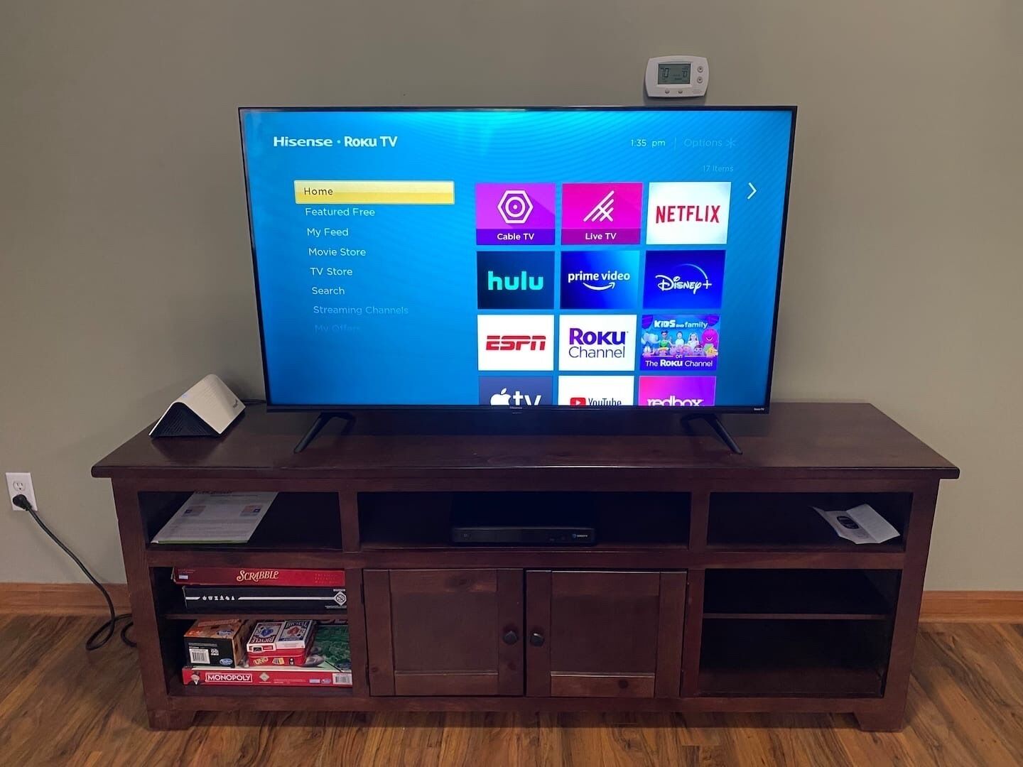 Een televisie op een houten standaard met een menuscherm waarop verschillende streamingdiensten worden getoond.