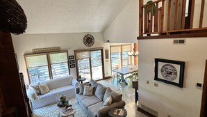 A spacious living area with a high ceiling, a dining table, and a staircase. - Updated Ozarks Lakefront Home-Lilly pad, kayaks, Private dock & boat ramp. (Sunrise Beach)