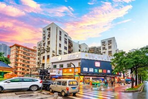 A street view with buildings, a crosswalk, and vehicles. - Junchao Light Luxury Hotel (Zhuhai)