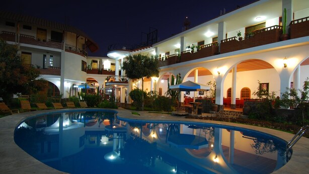 A hotel with a swimming pool, outdoor seating, and multiple balconies. - Hotel Alegria Nasca (Nazca)