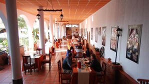 A spacious restaurant with high ceilings, terracotta tiled floors, and a long counter with patrons dining. - Hotel Alegria Nasca (Nazca)
