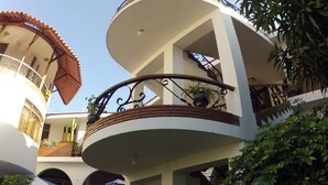 A multi-level building with a central courtyard featuring a wooden bench and potted plants. - Hotel Alegria Nasca (Nazca)